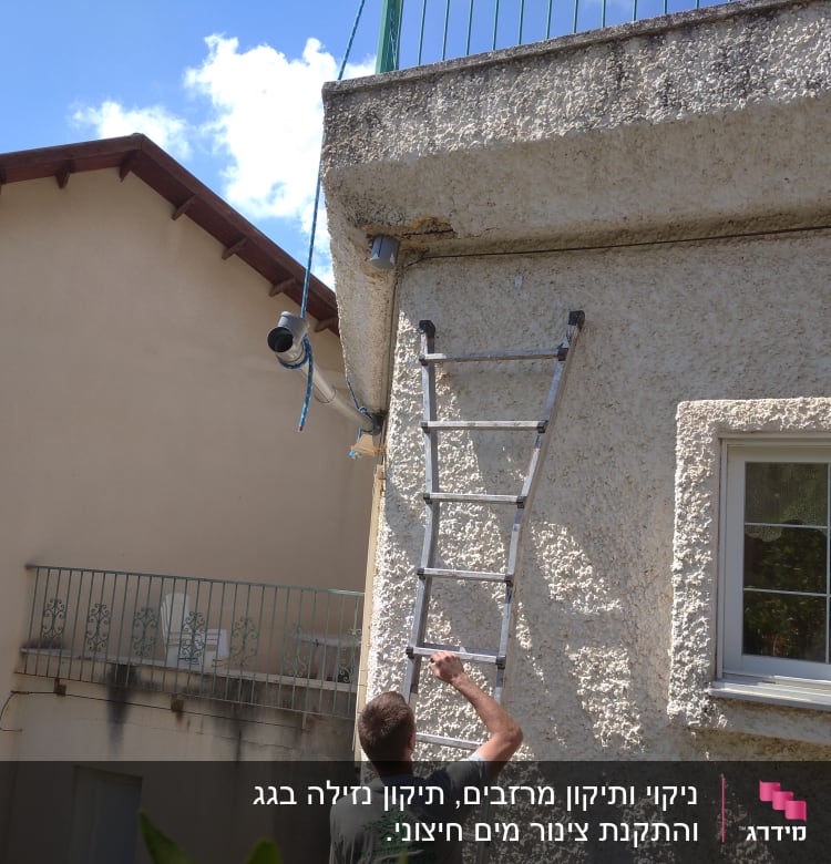 אדם עם סולם ליד גג שטוח עם מעקה